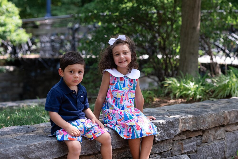 siblings pose on brick wall in downtown Frederick MD