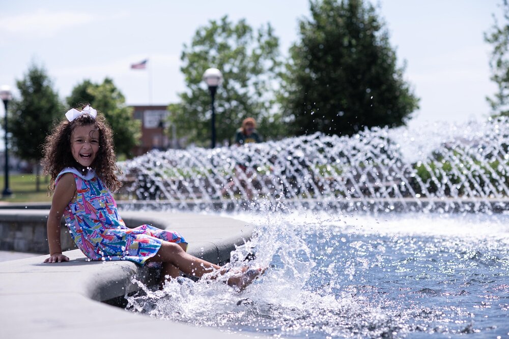 girl kicks water in downtown Frederick MD fountain