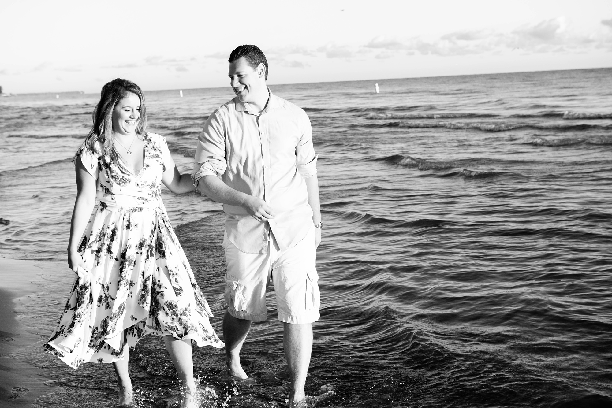 couple walks through ocean during destination beach engagement photos 