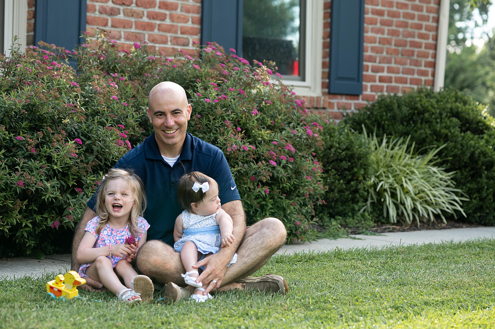 dad holds daughters during first birthday portraits in Frederick MD
