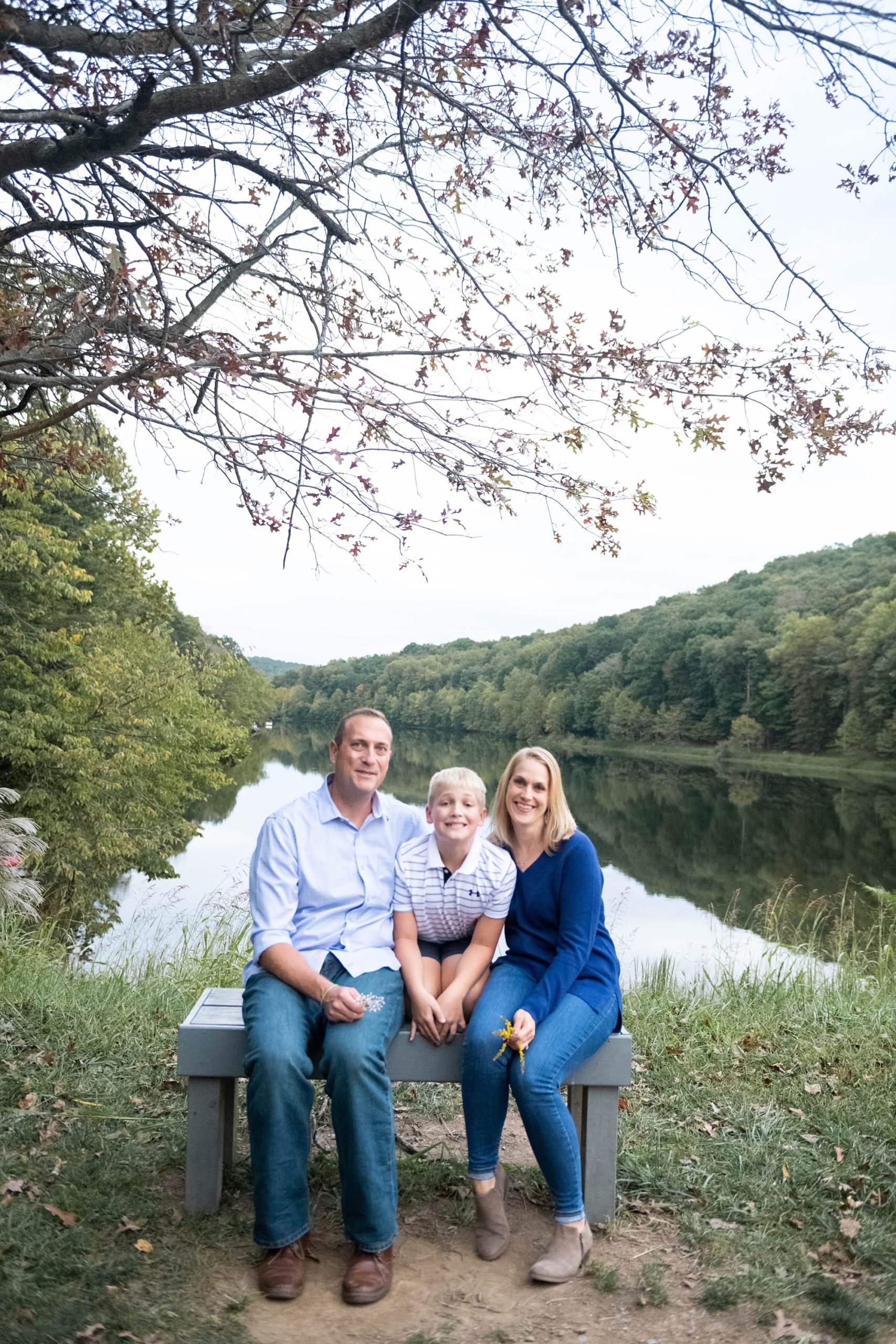 parents pose with son by lake during Photo Session in Lake Linganore