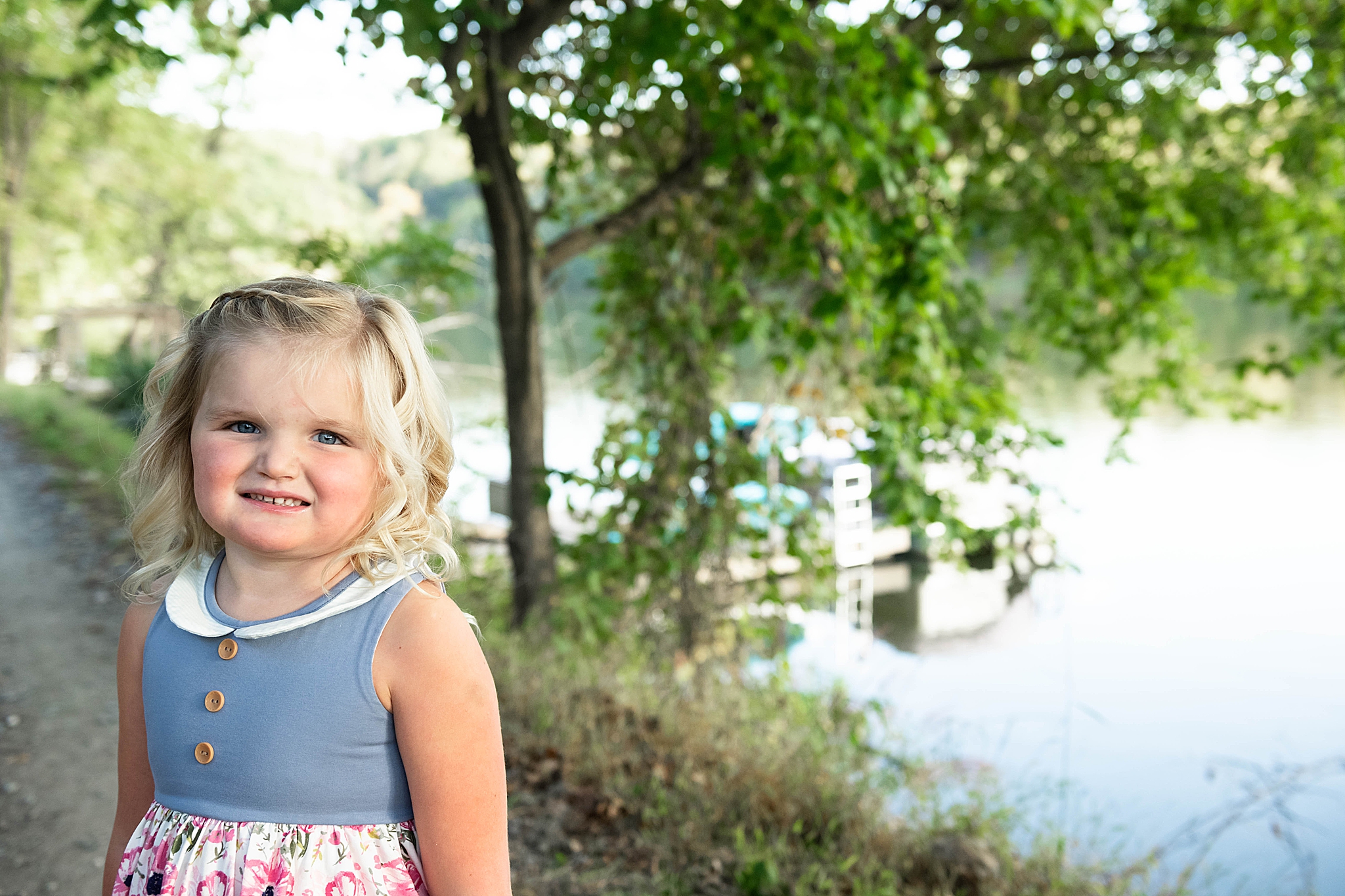 little girl poses by lake