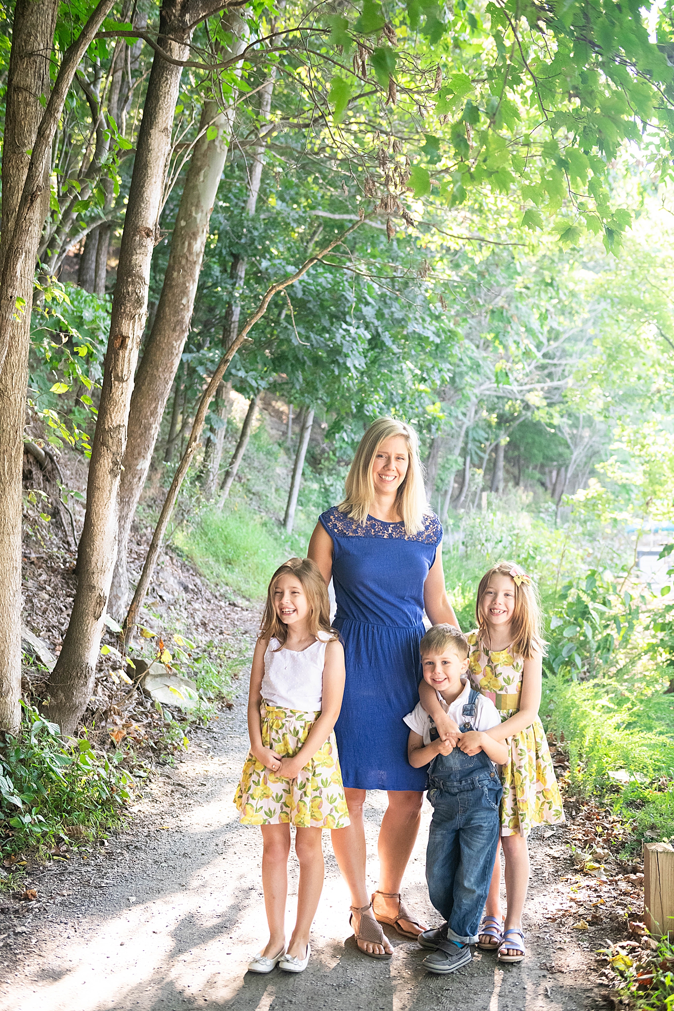mom stands with three children during fall family photos