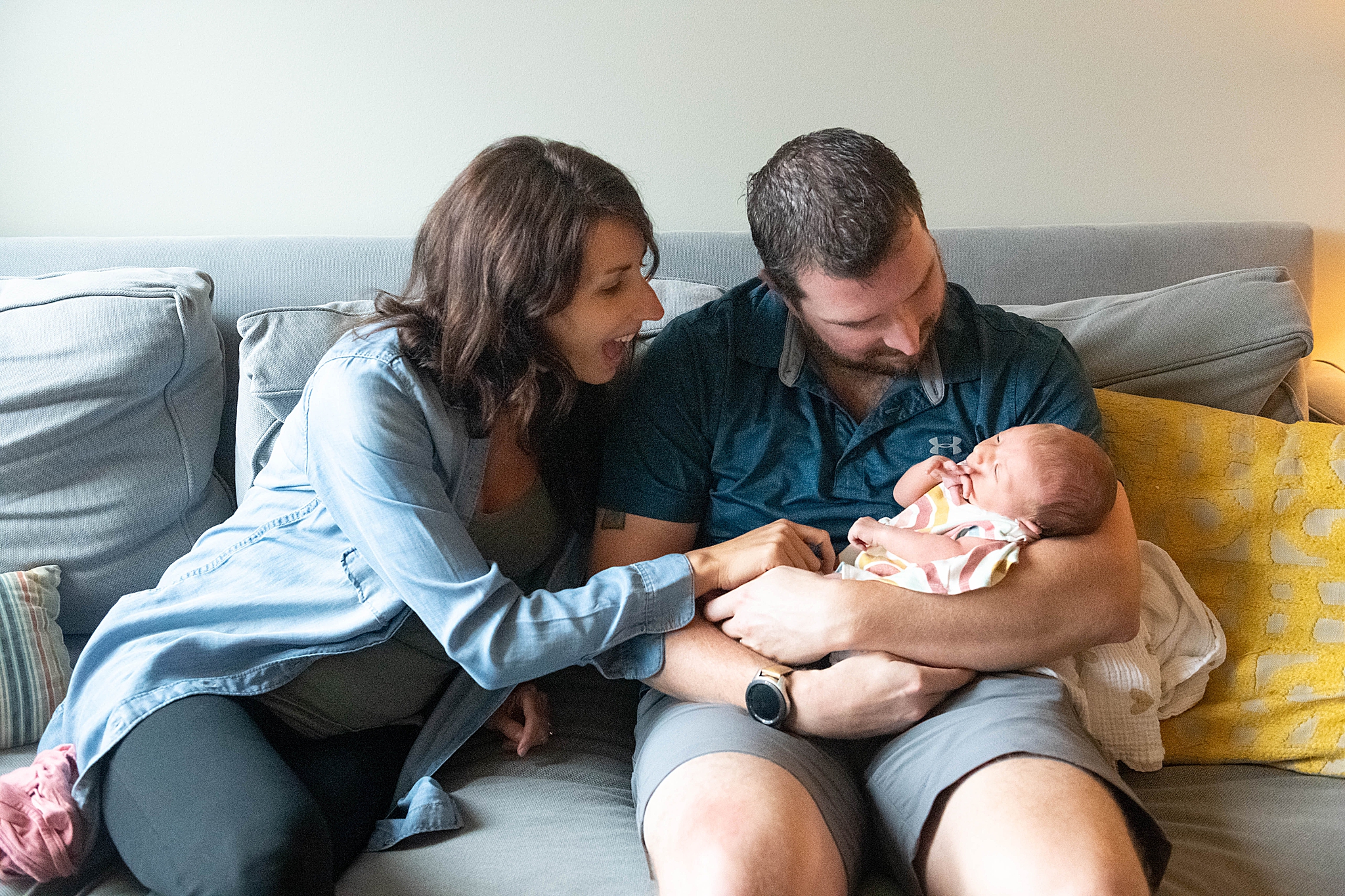 family of three sits on couch during Washington DC Lifestyle Newborn