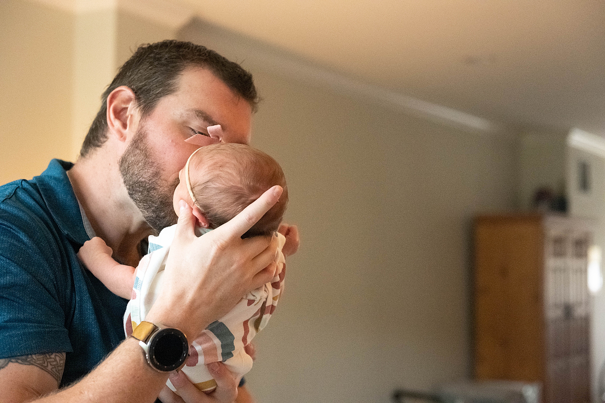 dad kisses newborn baby girl