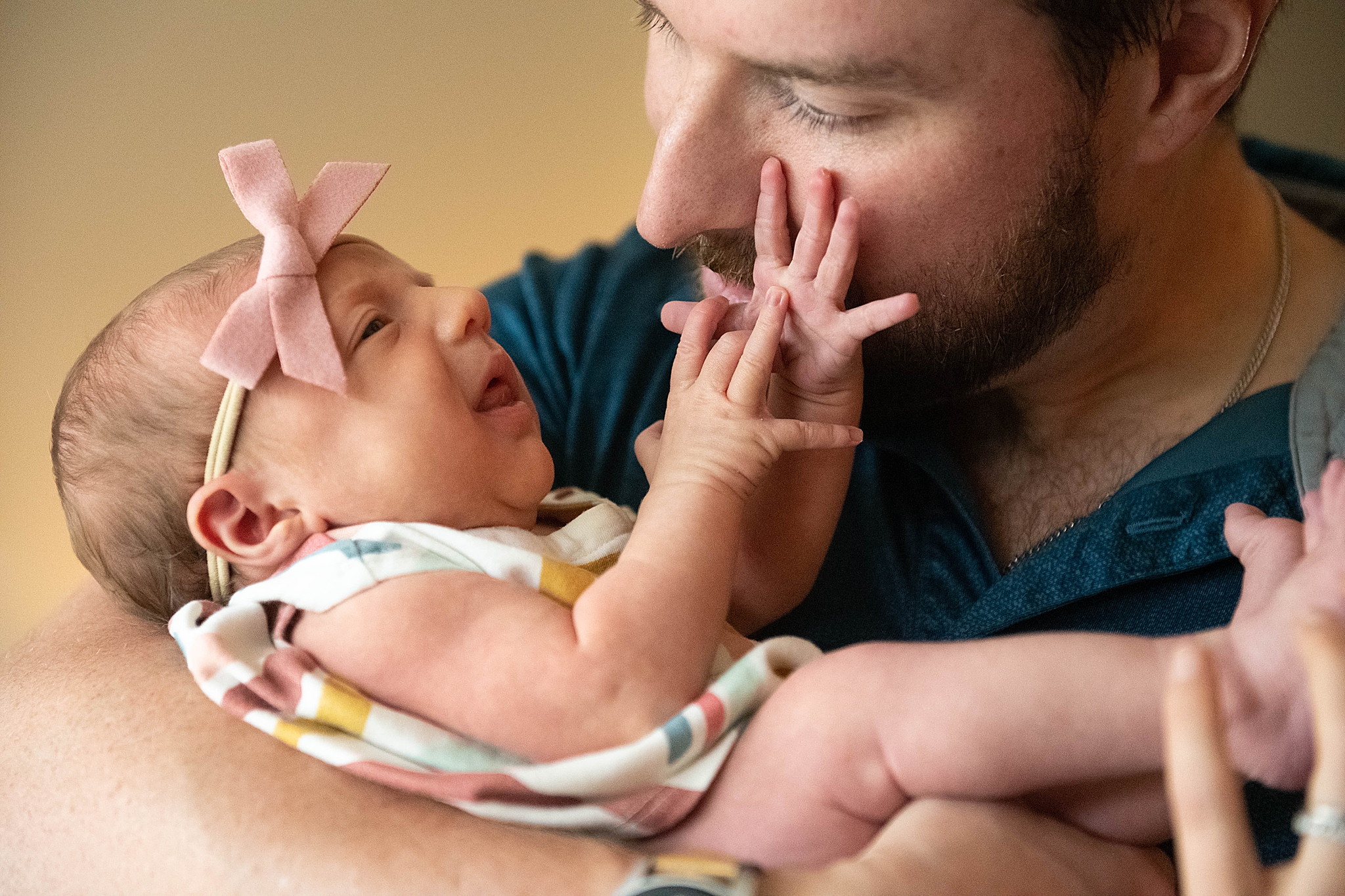 newborn baby girl plays with dad's face during Washington DC Lifestyle Newborn session