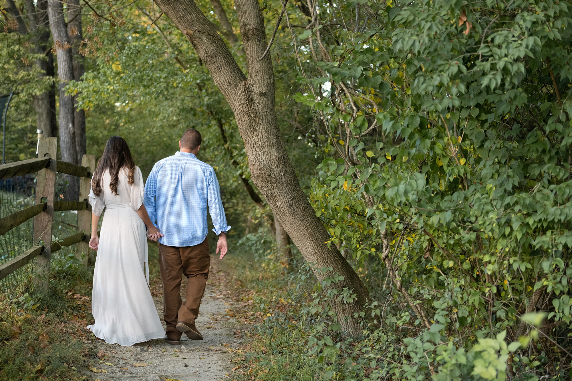 mom and dad walk in woods during Frederick County family portraits