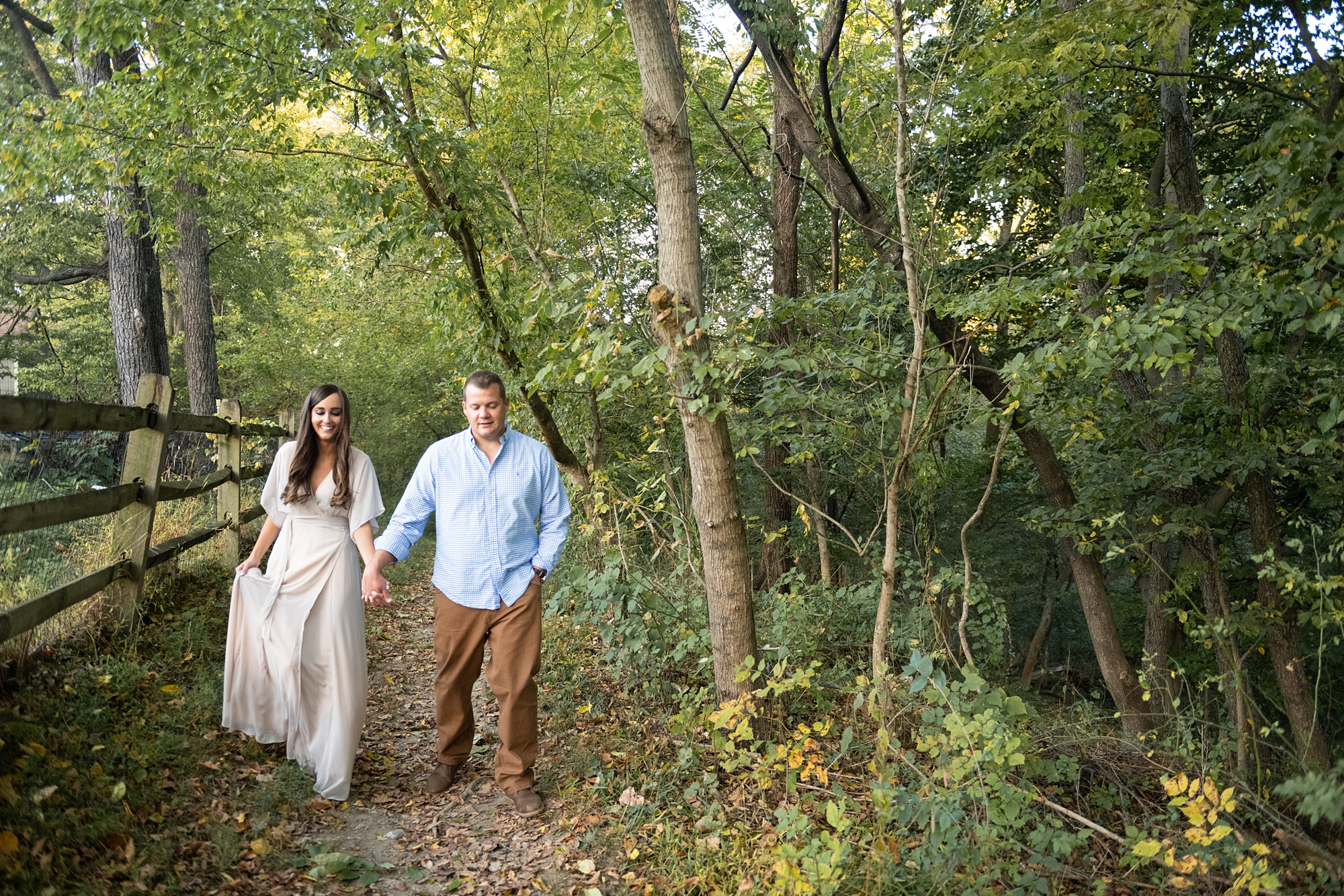 couple walks through woods of Frederick County