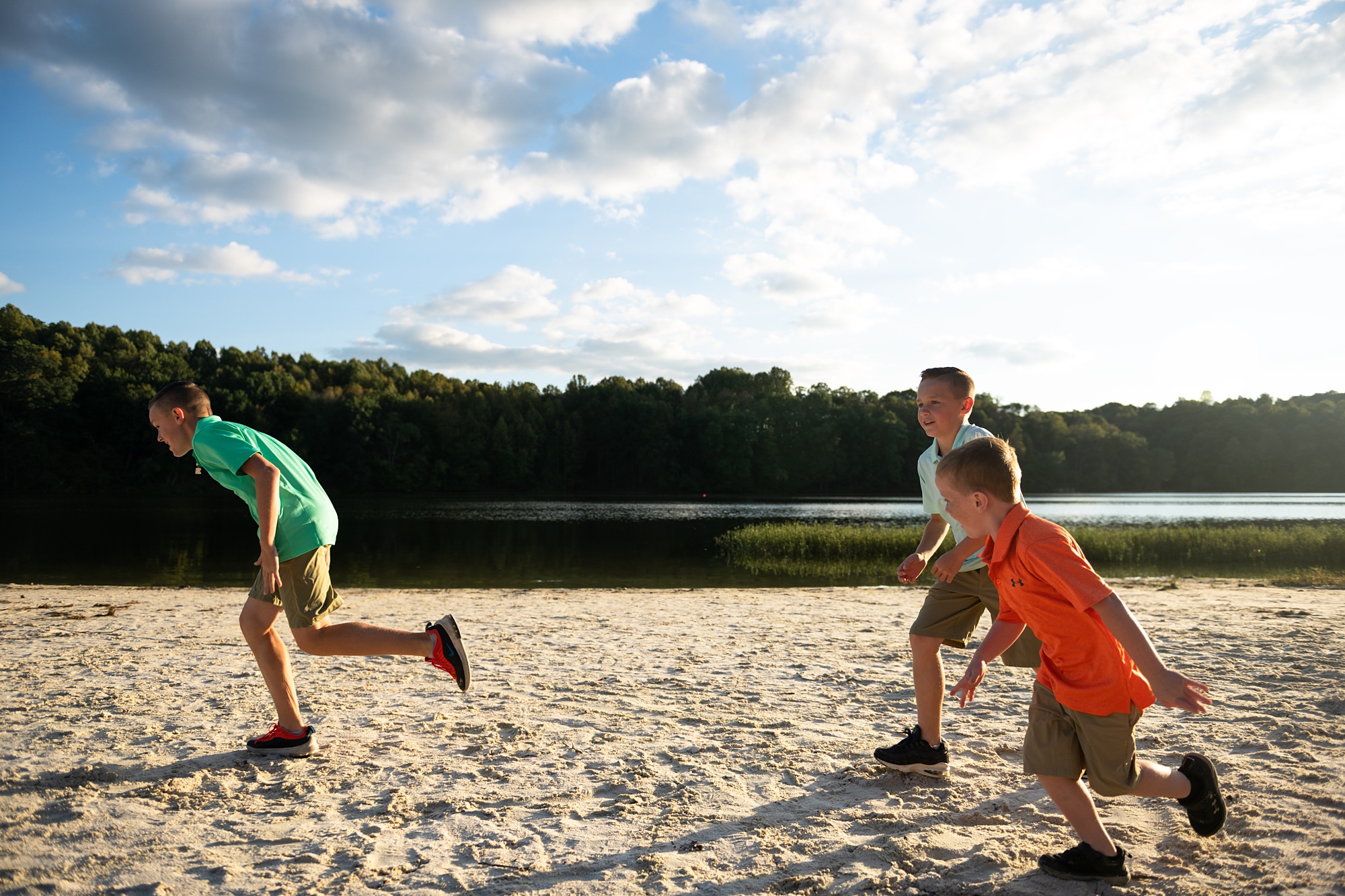 brothers run along sand in Lake Linganore