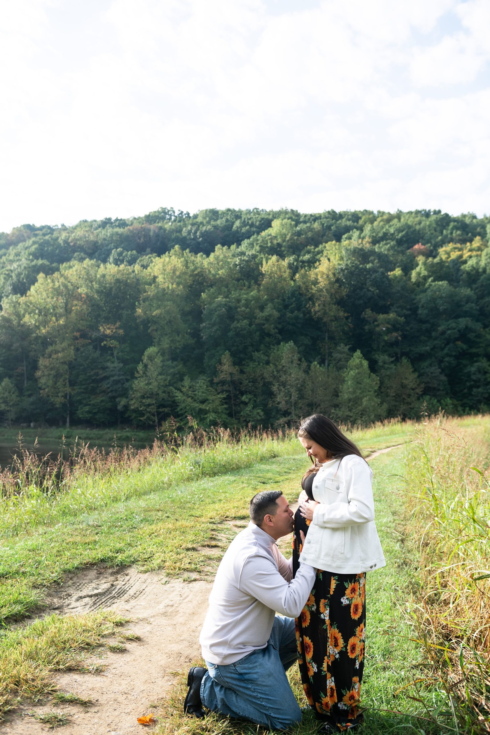 husband kisses wife's stomach during Lake Linganore maternity session