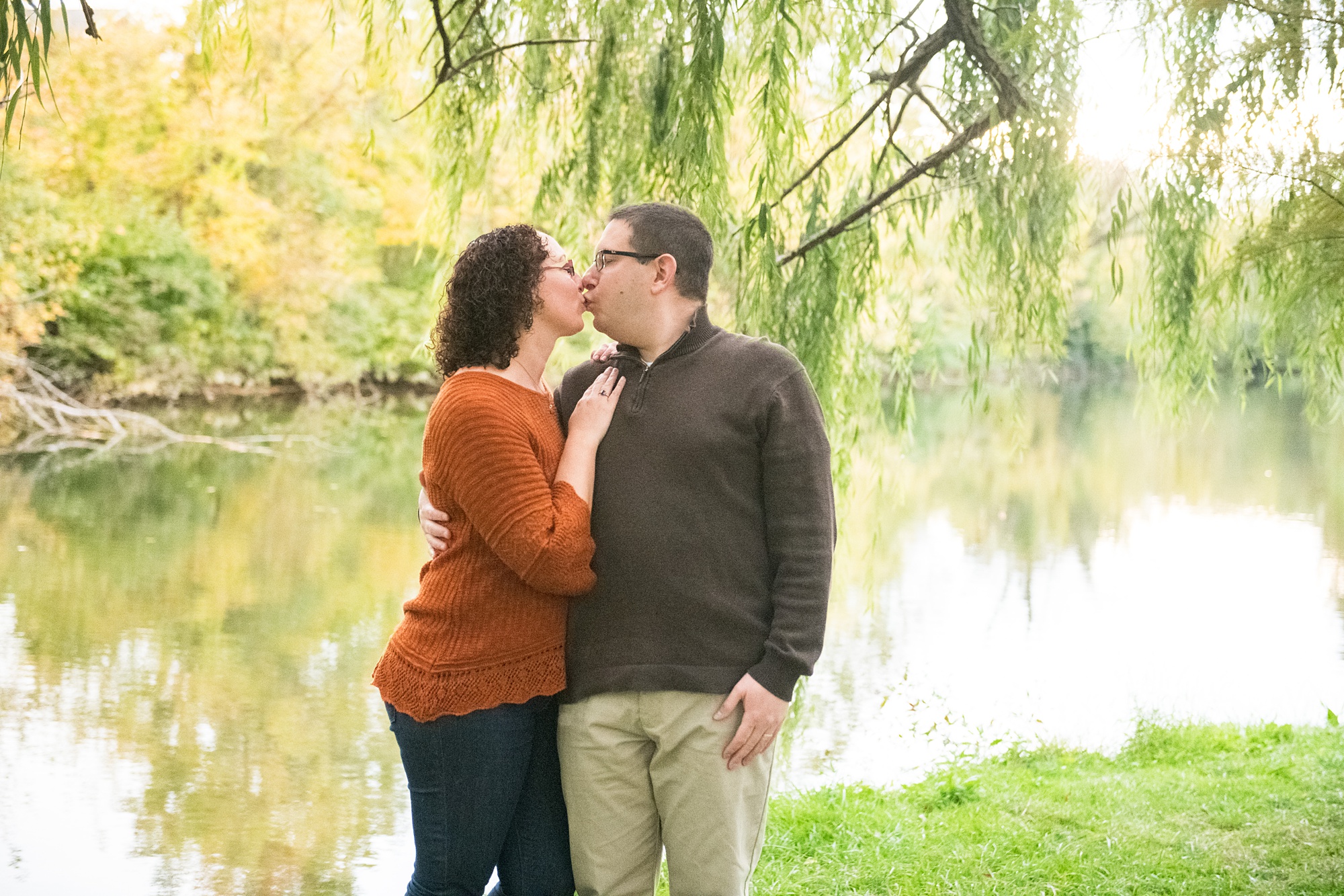 parents kiss during Baker Park family portraits in Downtown Frederick