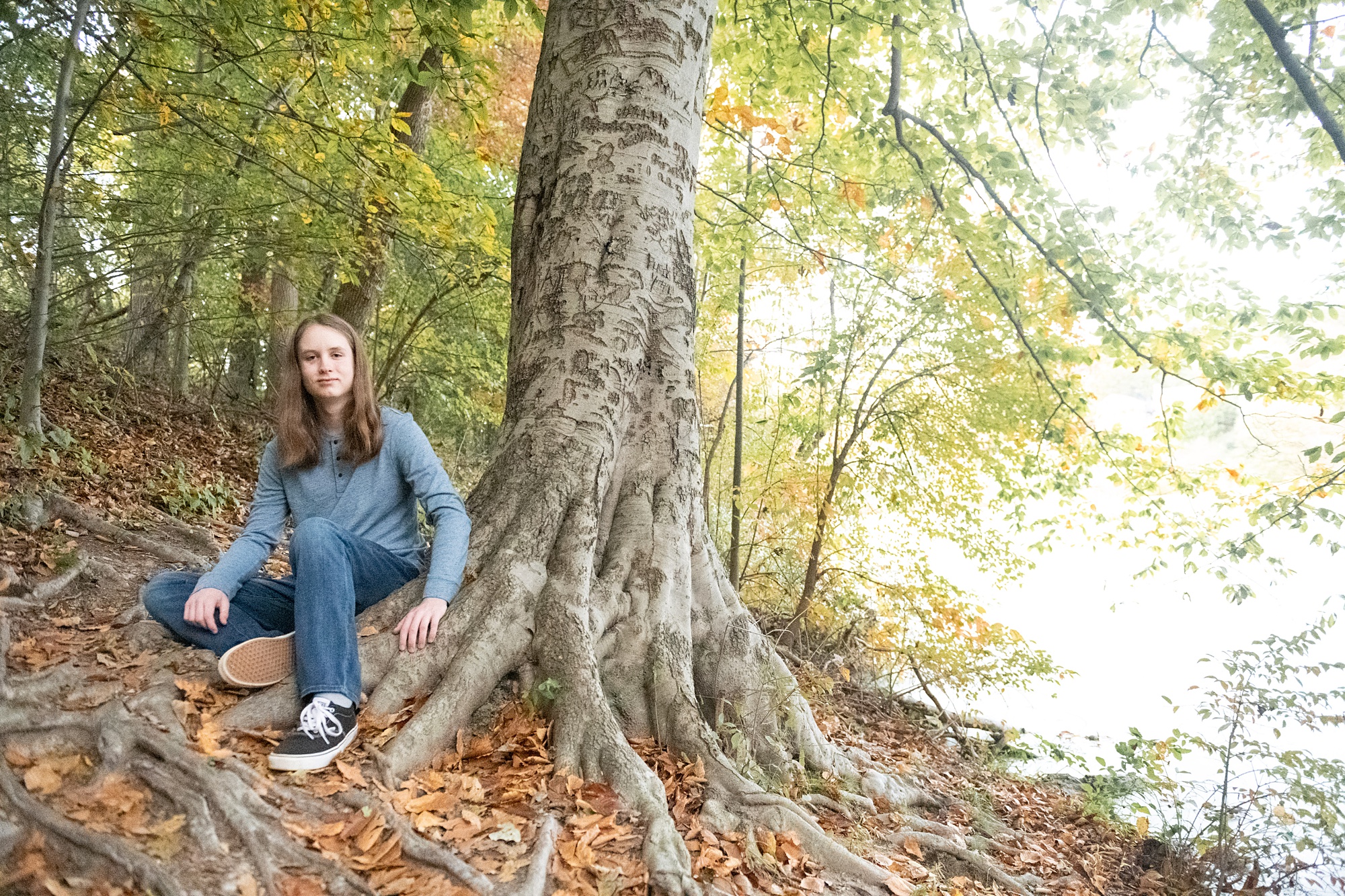 senior sits by roots of tree in Maryland 