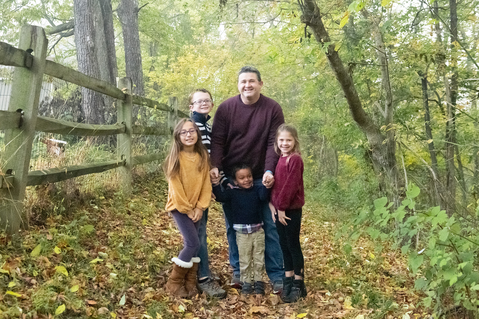 dad poses with kids on trail in Lake Linganore