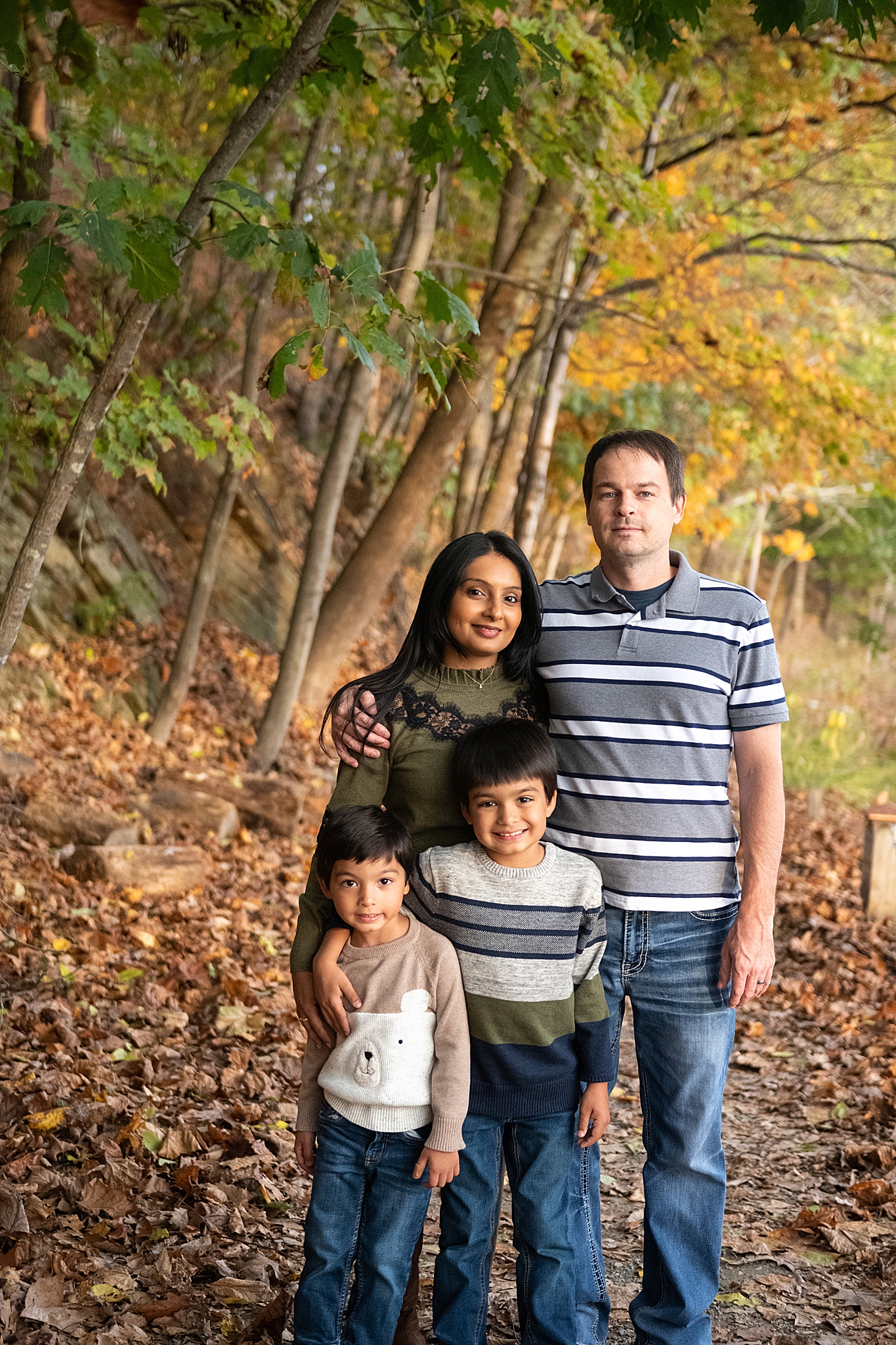 family of four poses for MD family photos in the fall