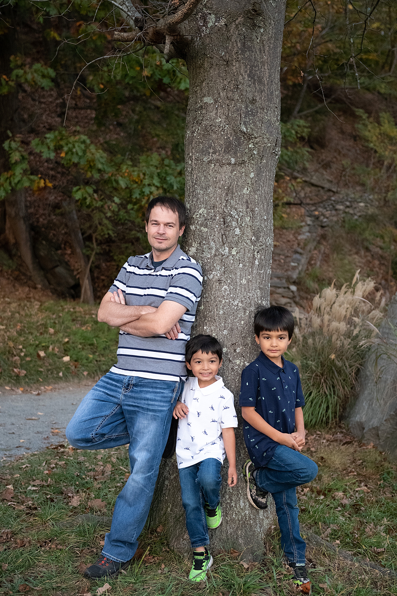 dad and boys pose together against tree during family photos 