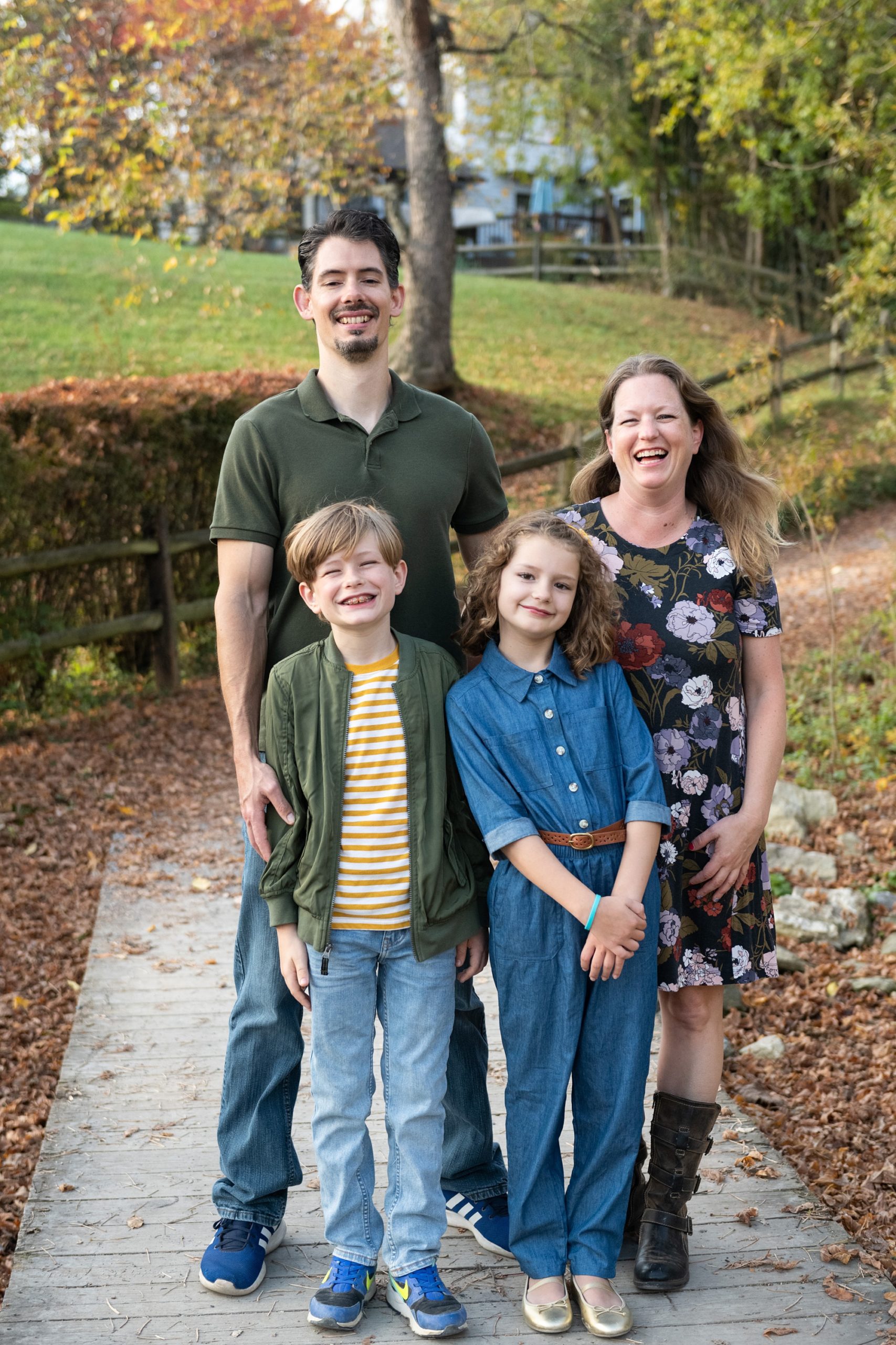 family of four laughs during fall photos in Lake Linganore 
