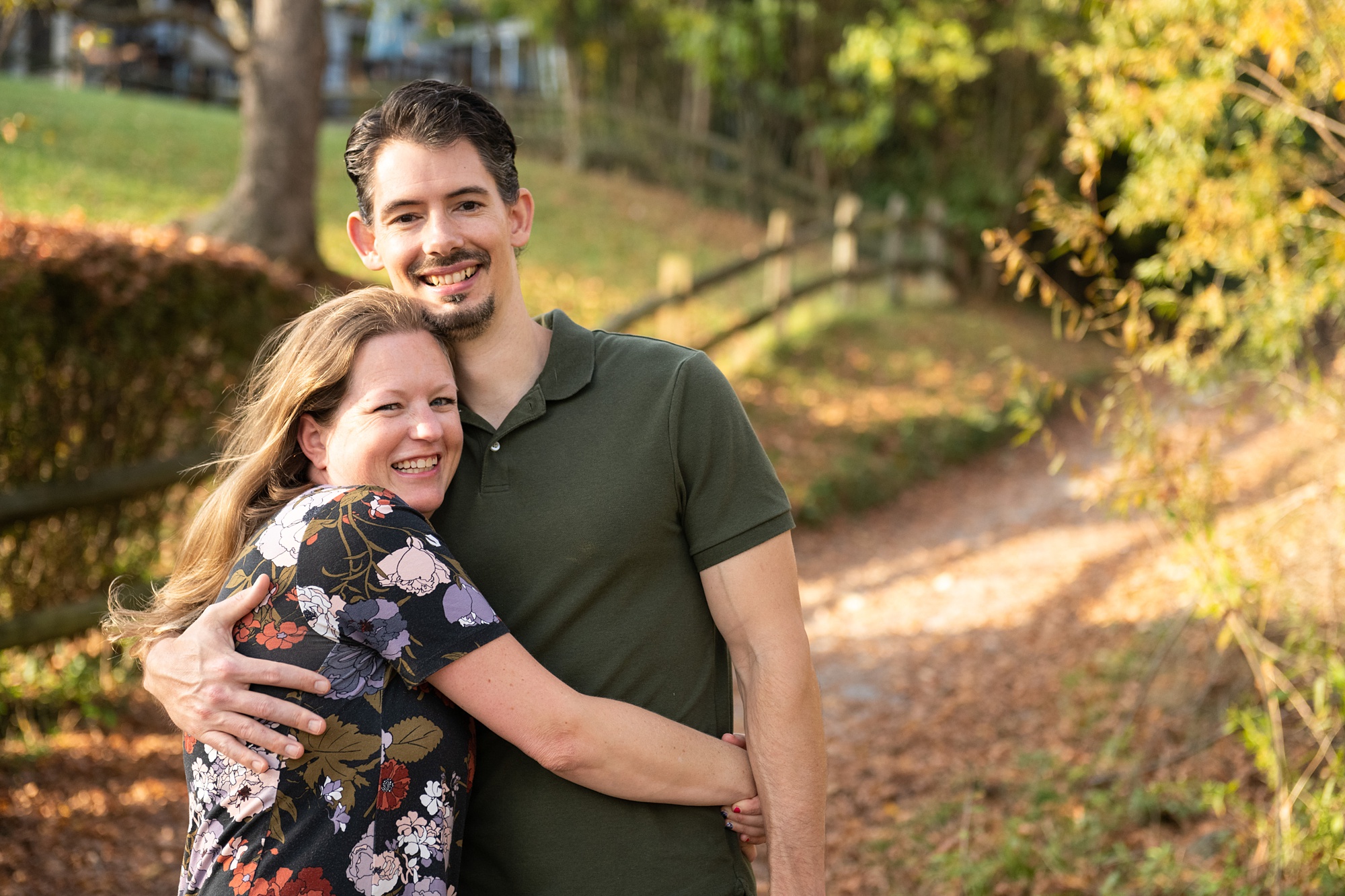 husband and wife hug on trail during fall family photos
