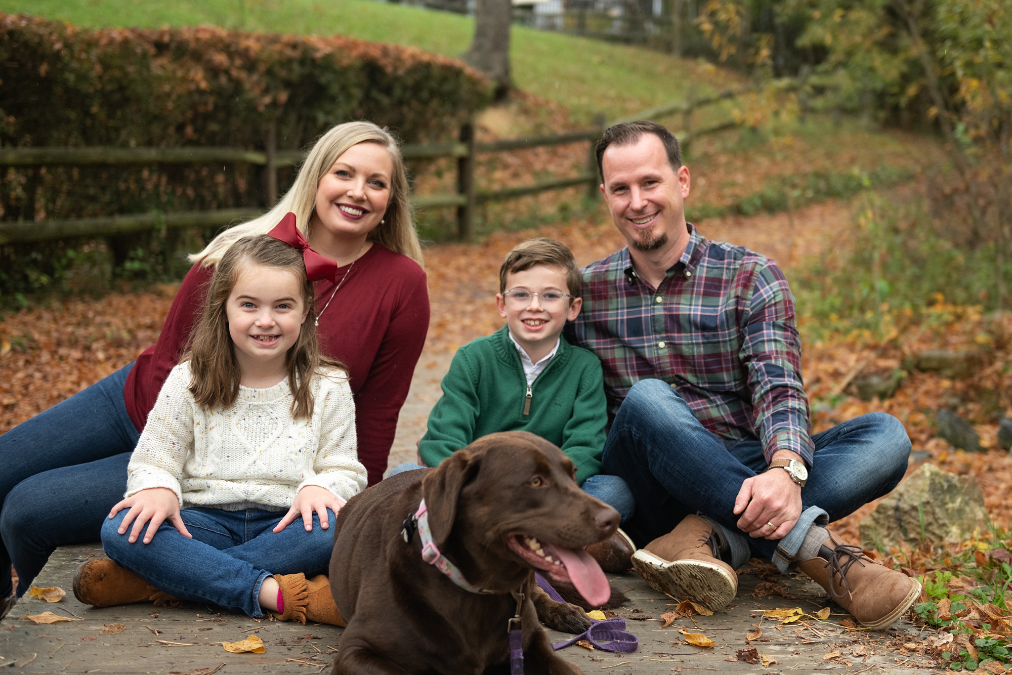 family of four poses with dog on walkway in Lake Linganore