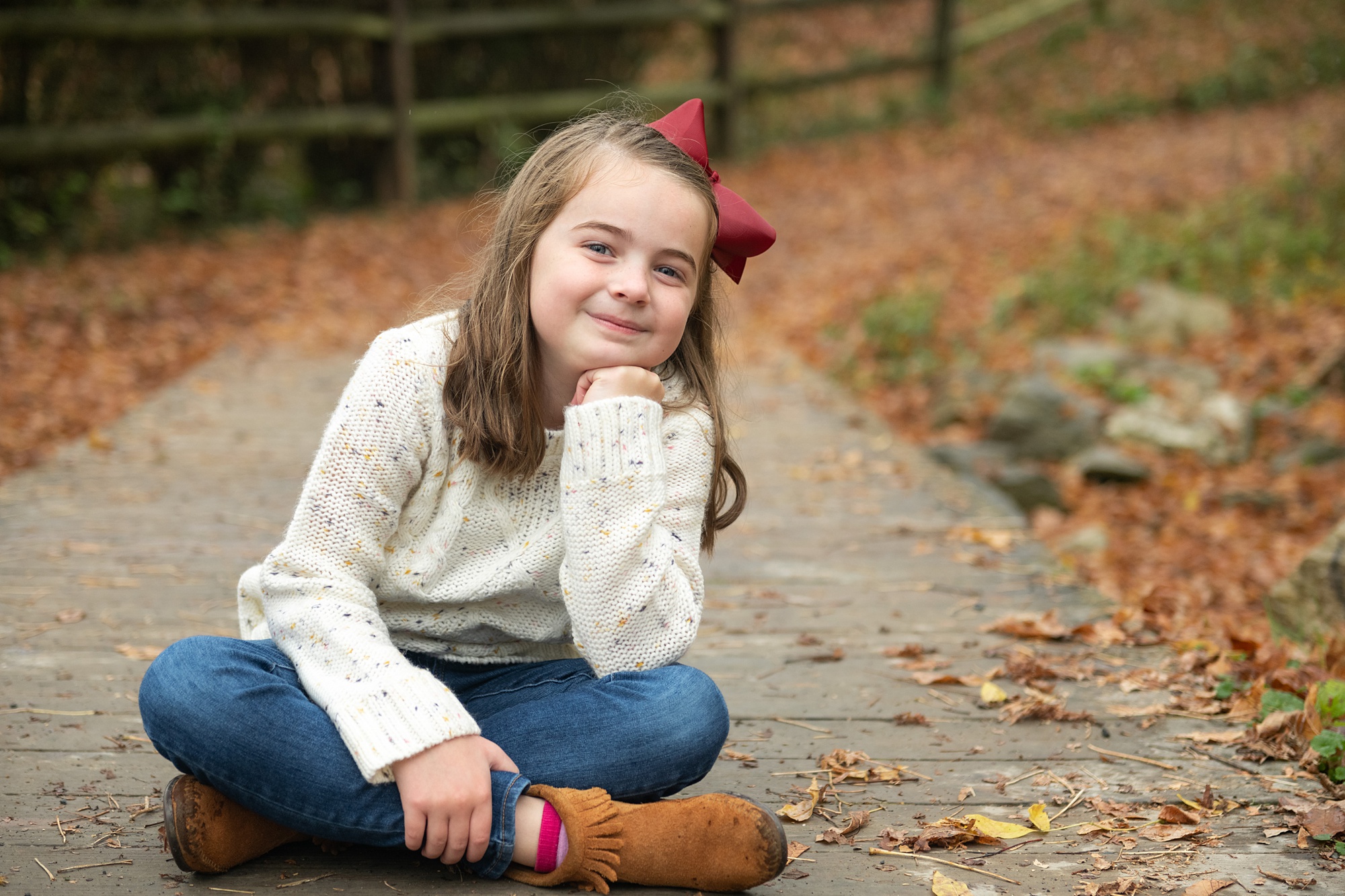 young girl poses on wooden walkway in Lake Linganore