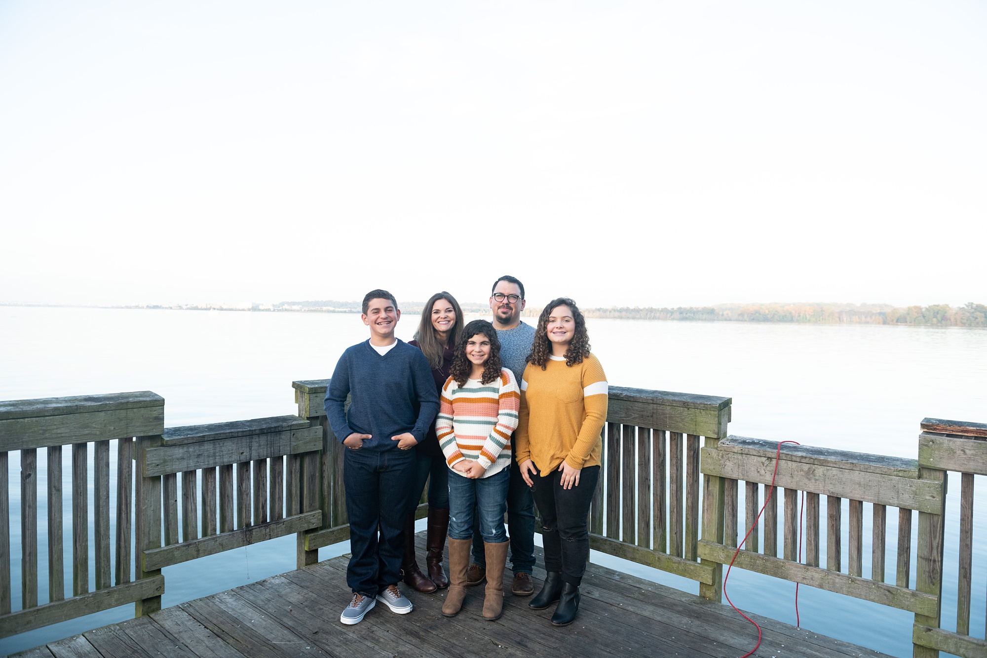 family poses on wooden dock in Alexandria VA