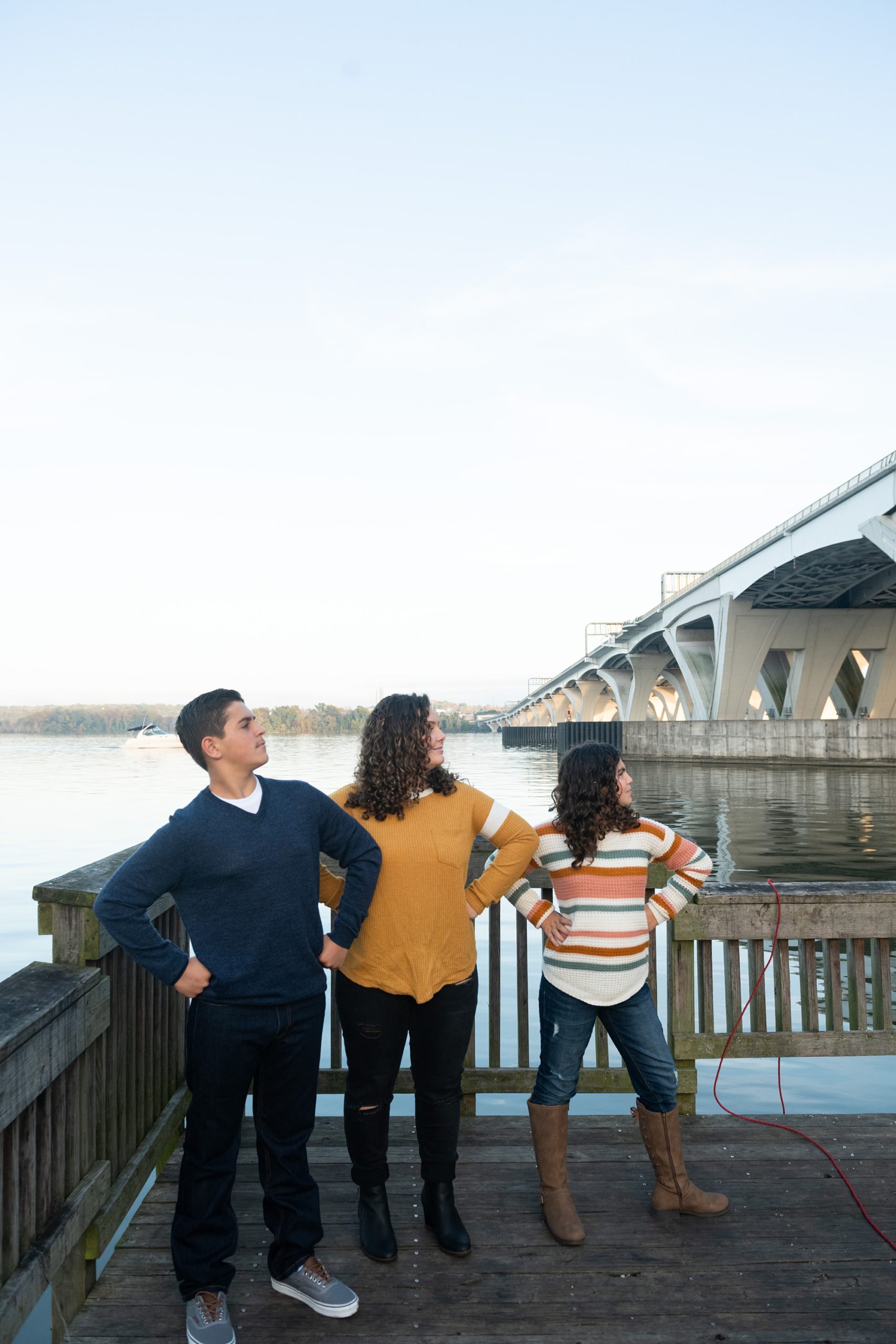 siblings pose playfully with hands on hips during Riverfront Family Portraits in Alexandria