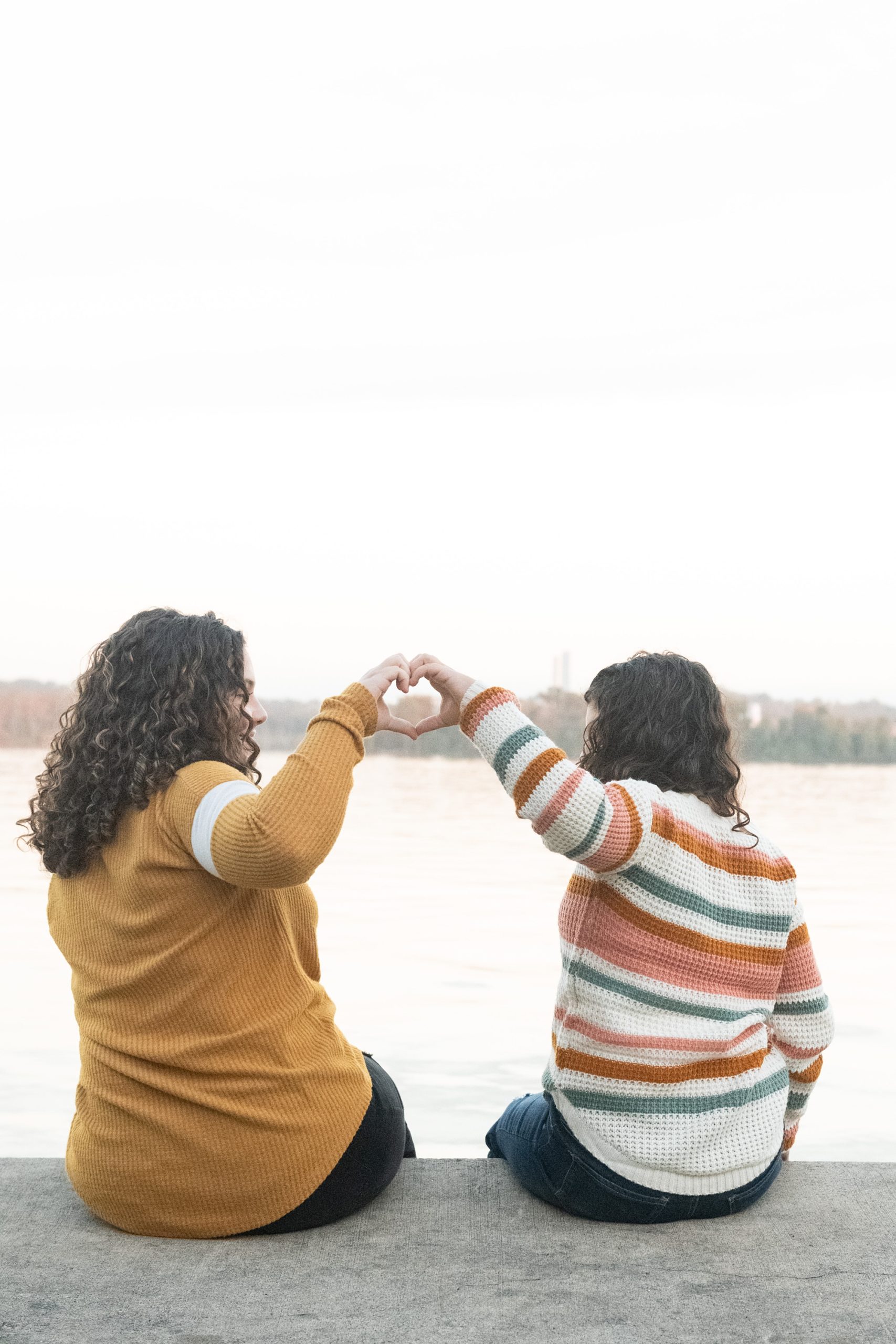 sisters make a heart in front of Potomac River